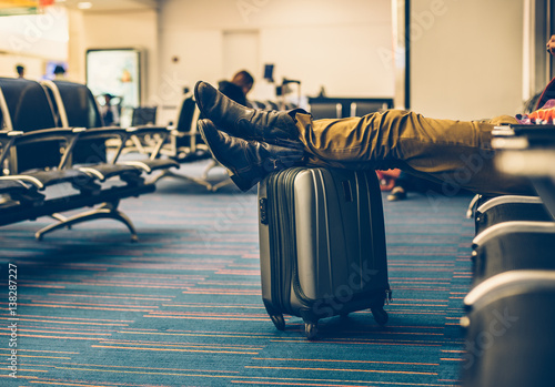 Принти на полотні Passanger with carry on luggage waiting for the delay flight in the airport teminal and relaxing