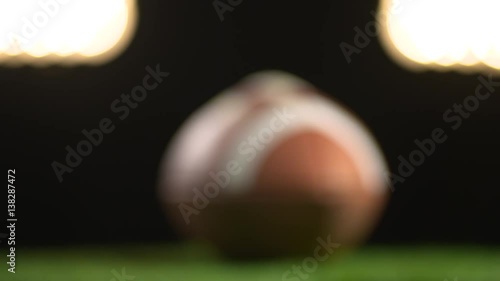 A football under the stadium lights are featured in the football background.