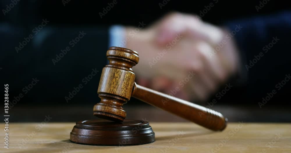 hand shake, auction scene of lawyers or notaries with gavel judge for the insurance compensation or criminal cases. concept of law and lawyer, judiciary and legislature applied to the democratic law. hand shake, auction scene of lawyers or notaries with gavel judge for the insurance compensation or criminal cases. concept of law and lawyer, judiciary and legislature applied to the democratic law.