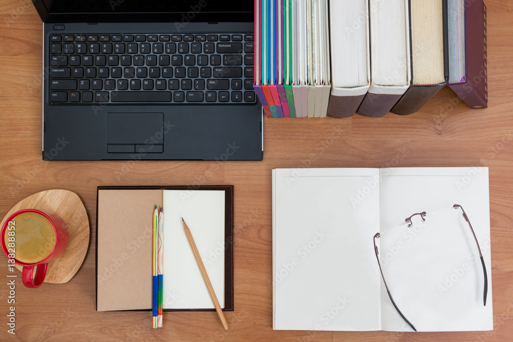 Orderly Desk with notebook , books, computer laptop,coffee and eyeglasses. Top view. Orderly Desk with notebook , books, computer laptop,coffee and eyeglasses. Top view.