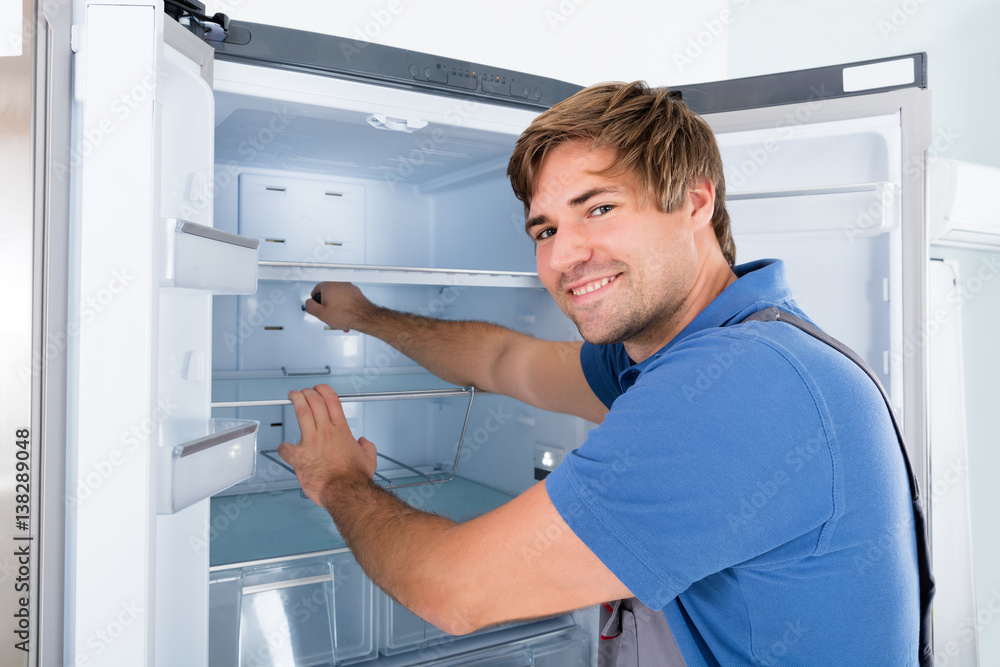 Technician Examining Refrigerator