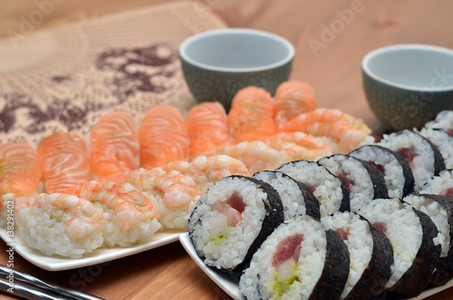 detail of maki sushi rolls and nigiri sushi with salmon and shrimp japan food on the table with soy sauce photo