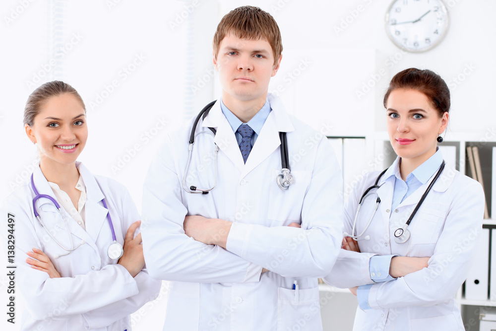Happy female doctor with medical staff at the hospital. Successful team at health care concept