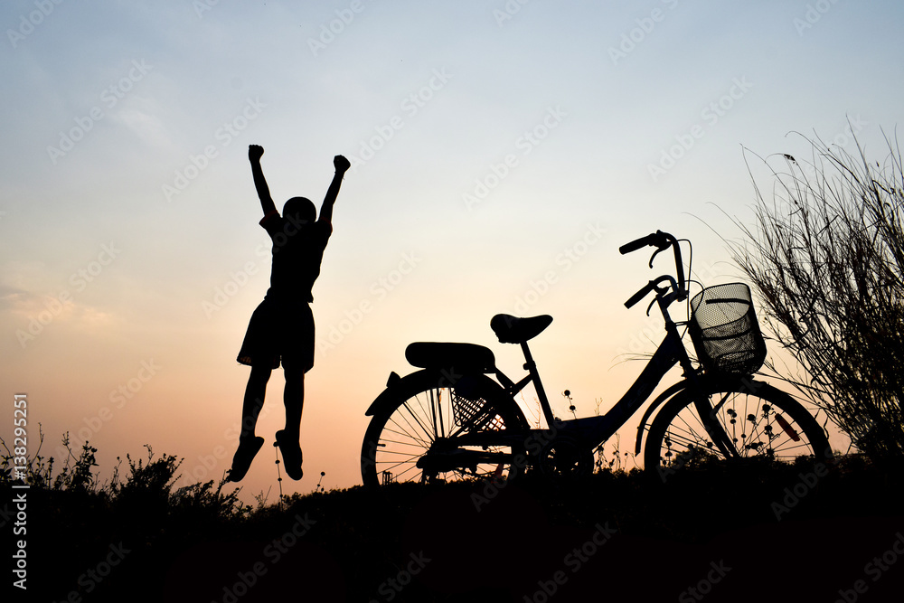 Silhouette boy and bicycle Background sunset