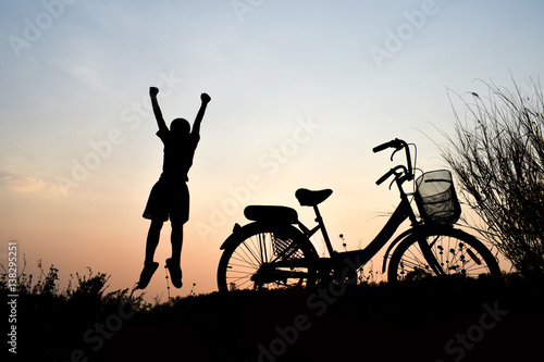 Silhouette boy and bicycle Background sunset