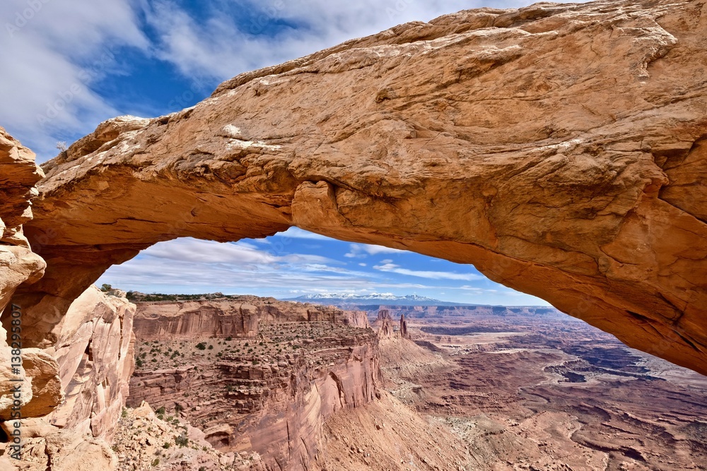 Natural sandstone arch and canyon views. Mesa Arch. La Sal Mountains. Canyonlands National Park. Moab. Utah. United States.