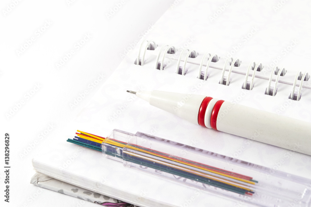 Office supplies - Mechanical pencil with pencil leads on white notebook Office supplies - Mechanical pencil with pencil leads on white notebook