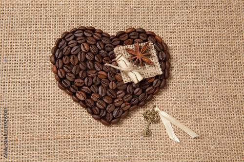 Heart of coffee beans with diminutive metal key and star anise