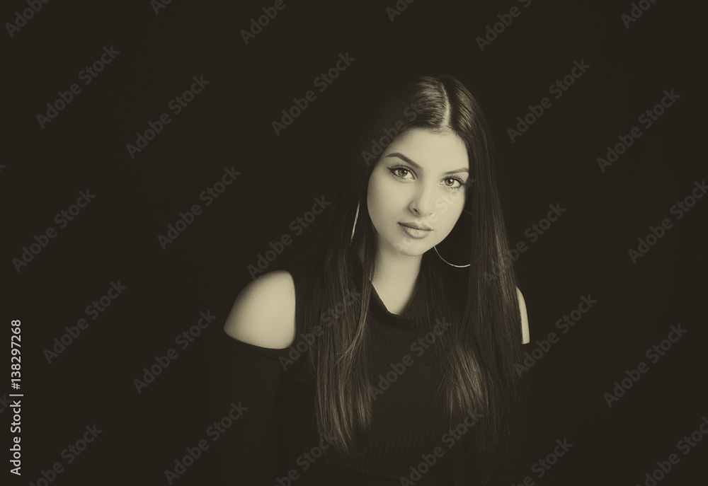 Fototapeta premium Young attractive woman with long black hair on black background.