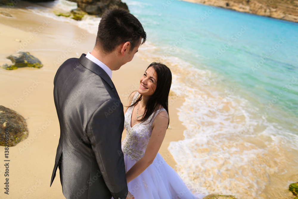 Fototapeta premium Groom and bride near the sea