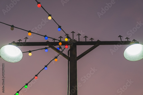 Iron street lamp, decorative spire adorned with multicolored lights.