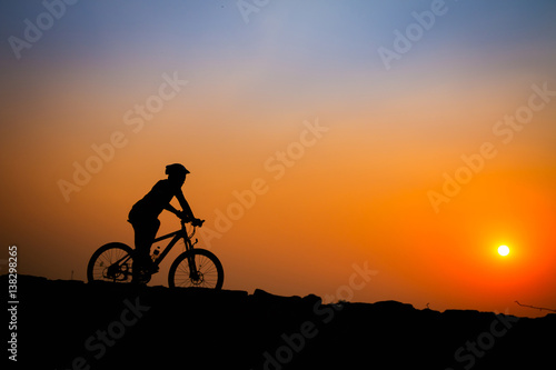 Silhouette of young man cyclist on sunset. © mrboylaptop