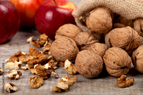 Whole walnuts, kernels and apples on the table