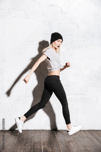 Full length of woman with black lips and hat running