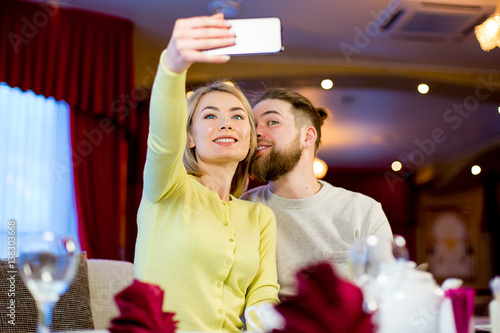 in love young couple in a restaurant makes selfie