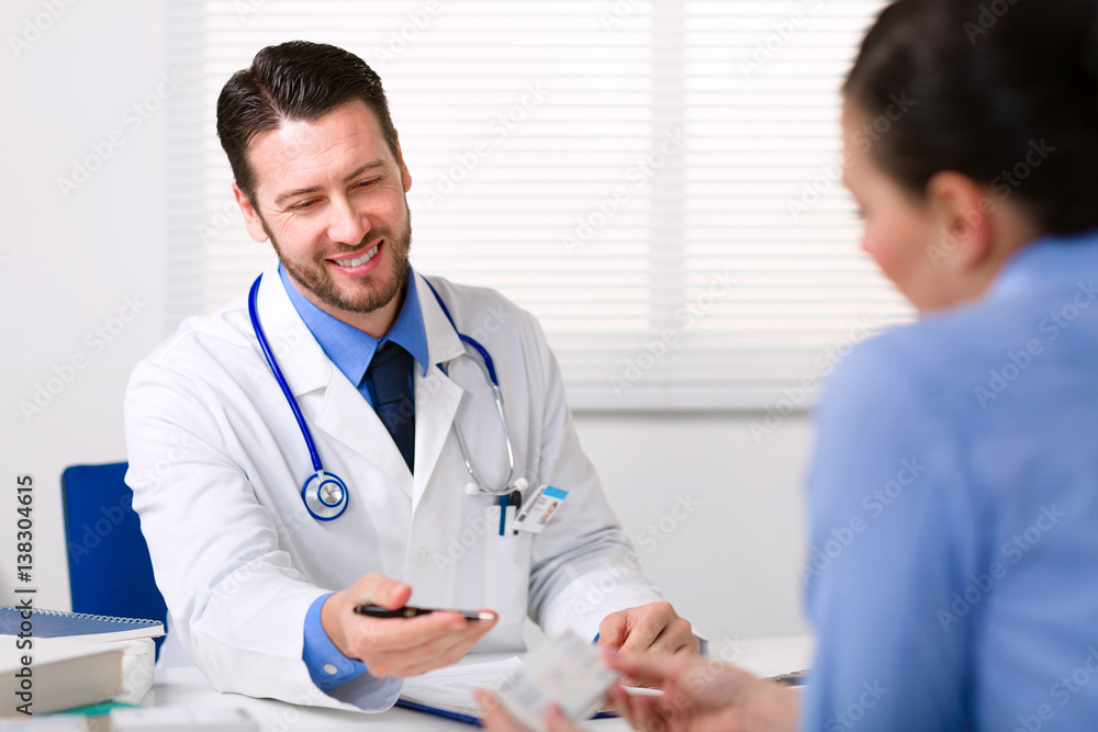 Doctor sitting at table in front of patient Doctor sitting at table in front of patient