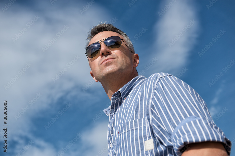 Handsome man. Outdoor male portrait. Middle-aged man, summer outdoor portrait over sky, image toned. Handsome man. Outdoor male portrait. Middle-aged man, summer outdoor portrait over sky, image toned.