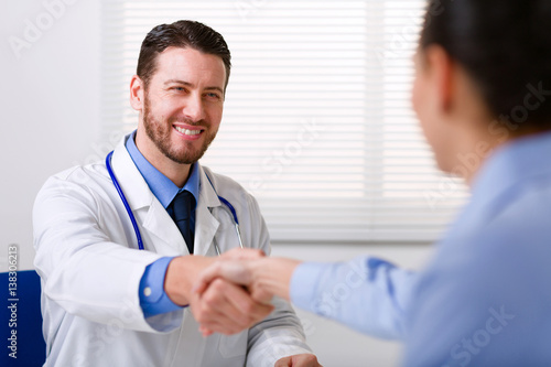 Doctor in white coat shake hand