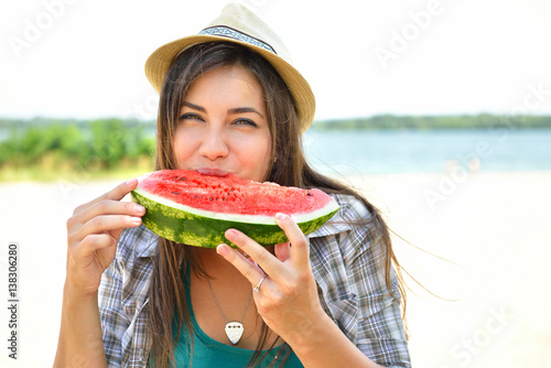 Happy young woman eating watermelon on the beach. Youth lifestyle. Happiness, joy, holiday, beach, summer concept.