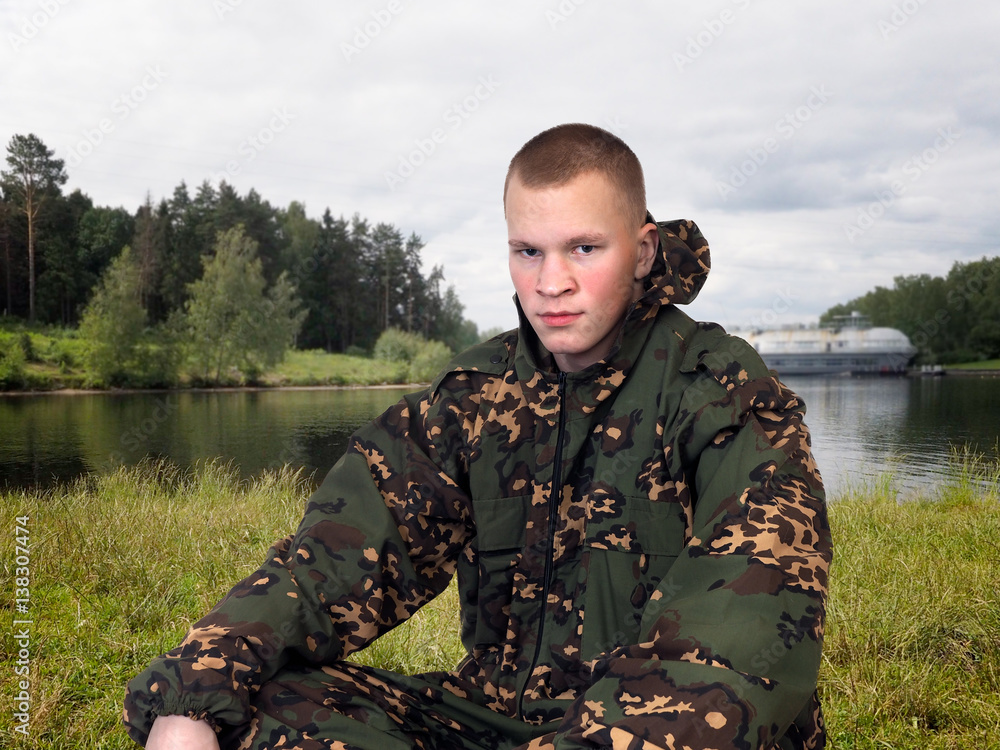 man in a camouflage uniform. Green grass, forest, river man in a camouflage uniform. Green grass, forest, river