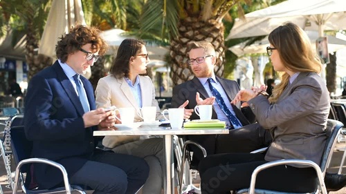 Irritated businesspeople sitting in the cafe and argue with each other
