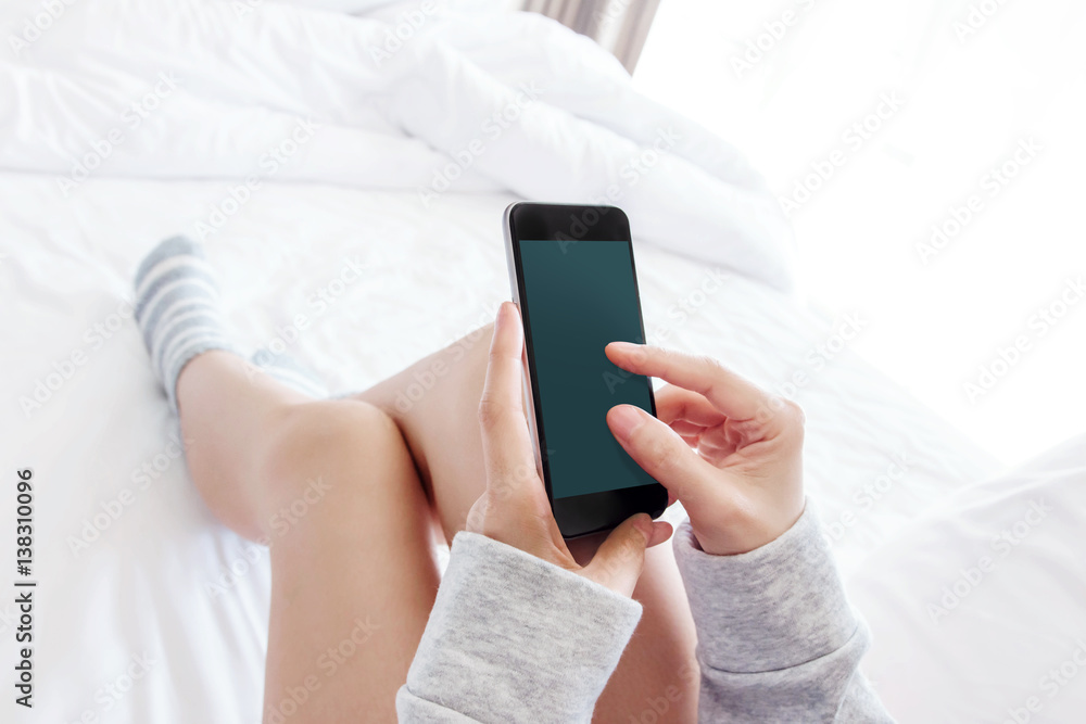 Female using Smart phone on bed, top view