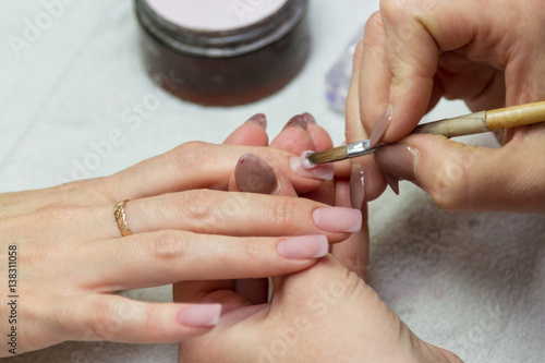 applying acrylic brush on nails