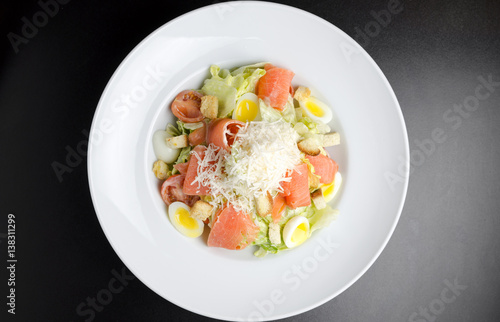 Salad with marinated salmon on a white plate