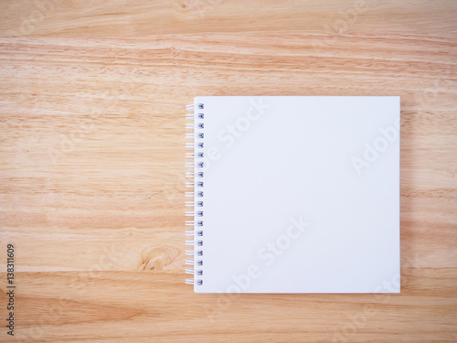 white cover notebook on brown wood desk background