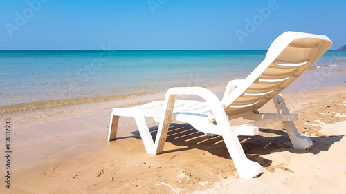 white armchair on the wet beach in sunny time