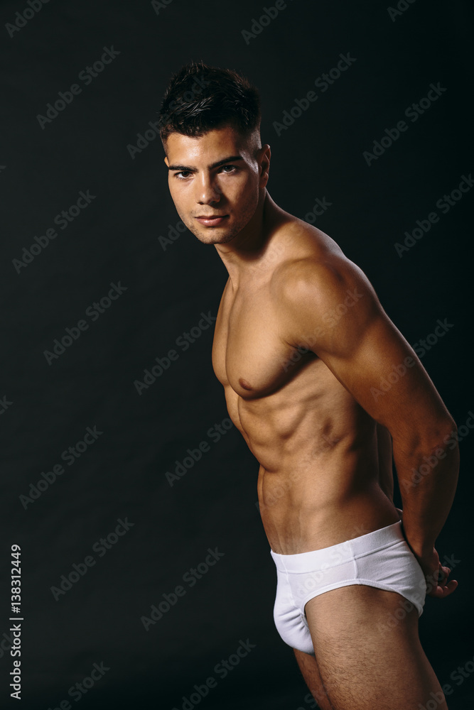 Fototapeta premium Handsome muscular young man posing in the studio