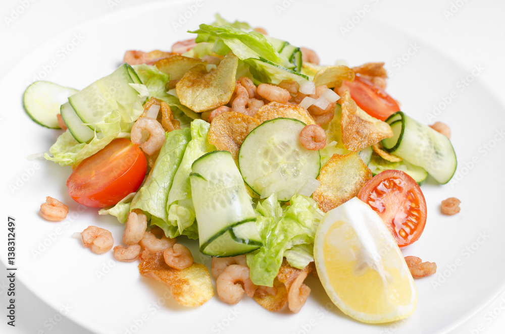 Salad from seafood and vegetables on a white plate