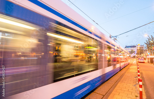 Amsterdam. Tram speeding at sunset in city streets