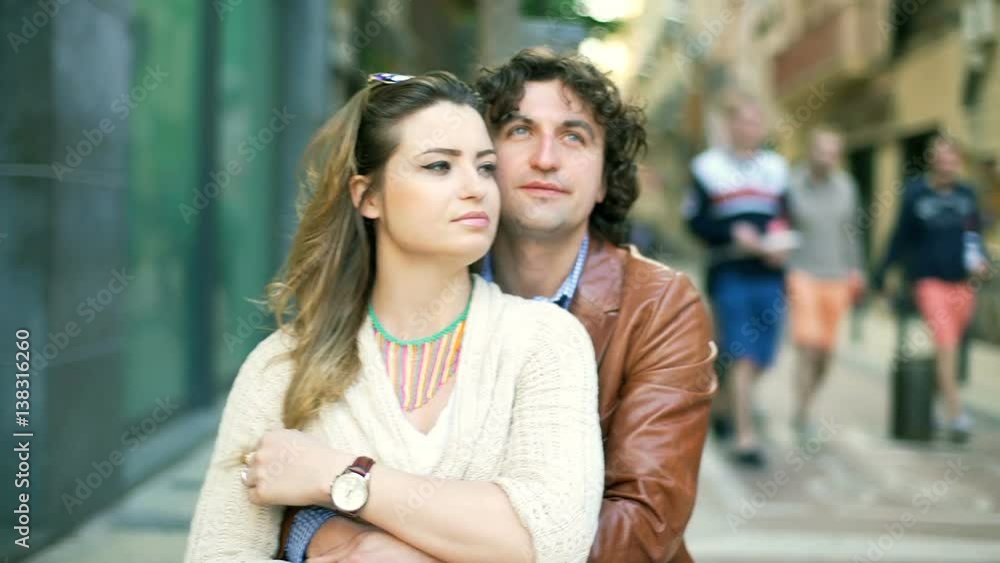 View of couple cuddling each other in the town, steadycam shot
View of couple cuddling each other in the town, steadycam shot