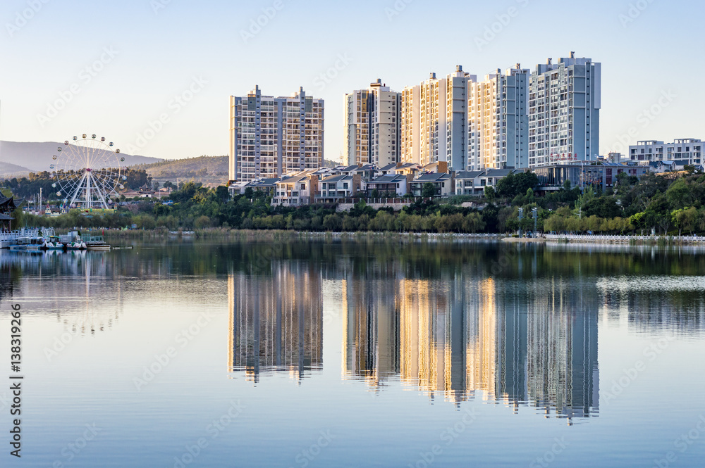 Residential buildings and ferris wheel water reflection in China