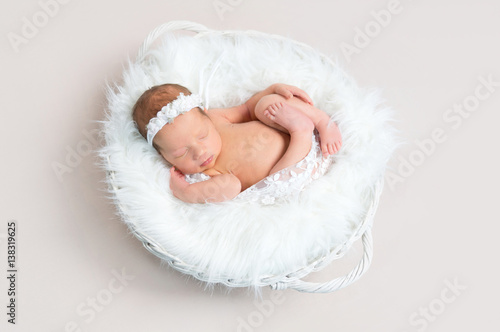 Child napping naked in a basket