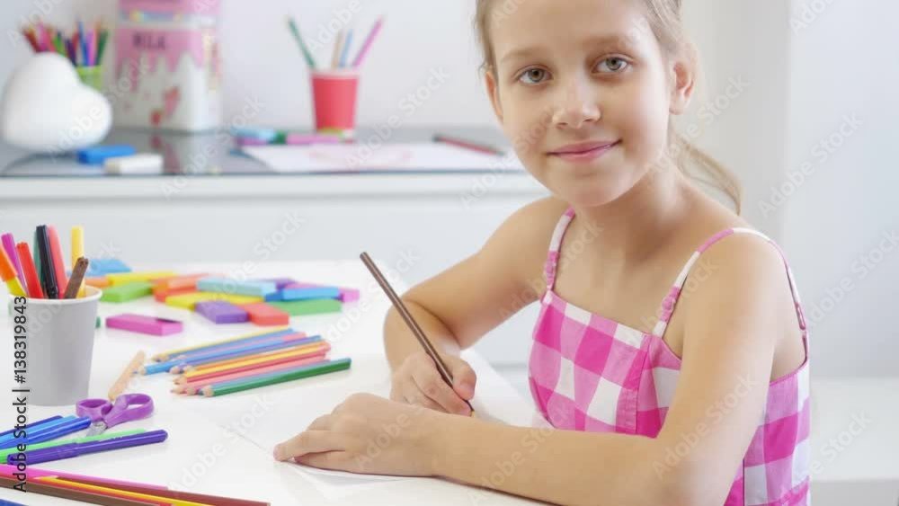 White 7 years old girl drawing and coloring on a paper at home. Girl looking at camera and smiling.
White 7 years old girl drawing and coloring on a paper at home. Girl looking at camera and smiling.