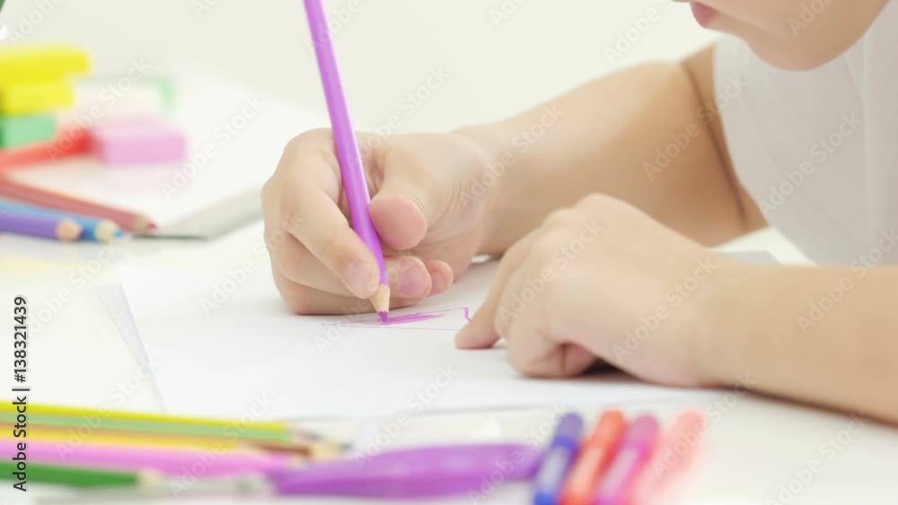 Little girl drawing a picture on the table. White 7 years old girl drawing and coloring on a paper at home. Little girl drawing a picture on the table. White 7 years old girl drawing and coloring on a paper at home.