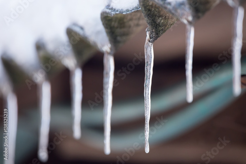 icicles hanging from the snowy roof, against the log walls. Space for copy text © Garmon