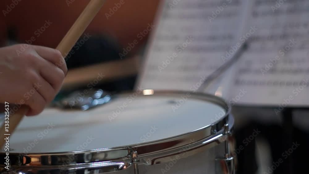 Boy playing drum reading sheet music in school Boy playing drum reading sheet music in school