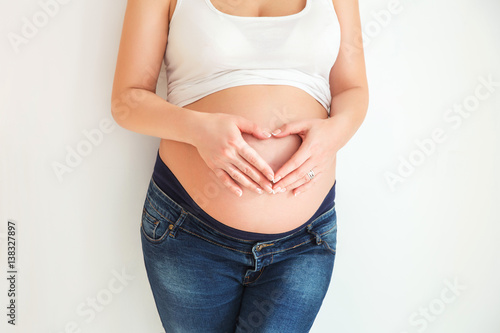 Pregnant girl woman holding hands heart symbol white background