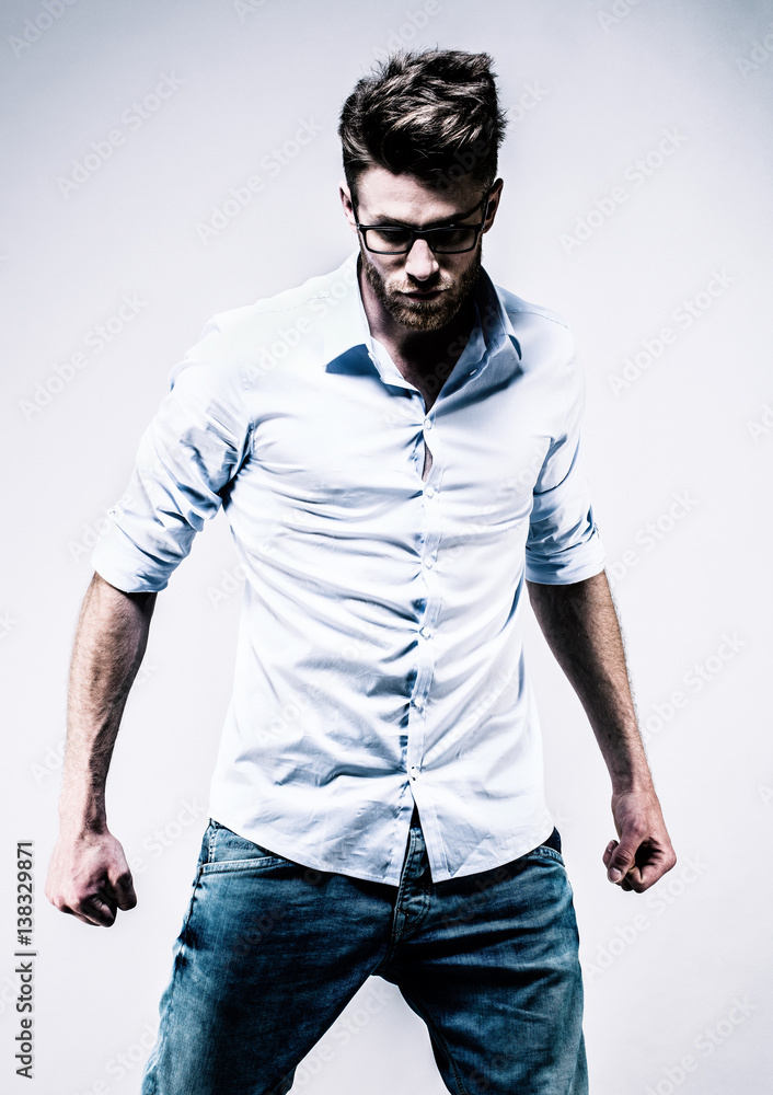 Jeune homme debout en chemise blanche, de face, les poings serrés Stock  Photo | Adobe Stock