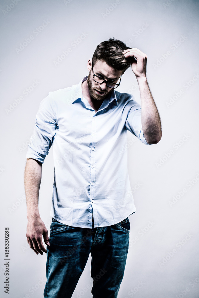 Jeune homme debout en chemise blanche, de face, une main dans les