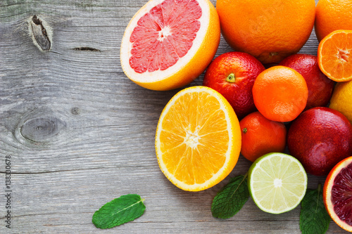 Lemon,red orange, orange, grapefruit,  lime, tangerine on old wooden table. Place for text. Background.