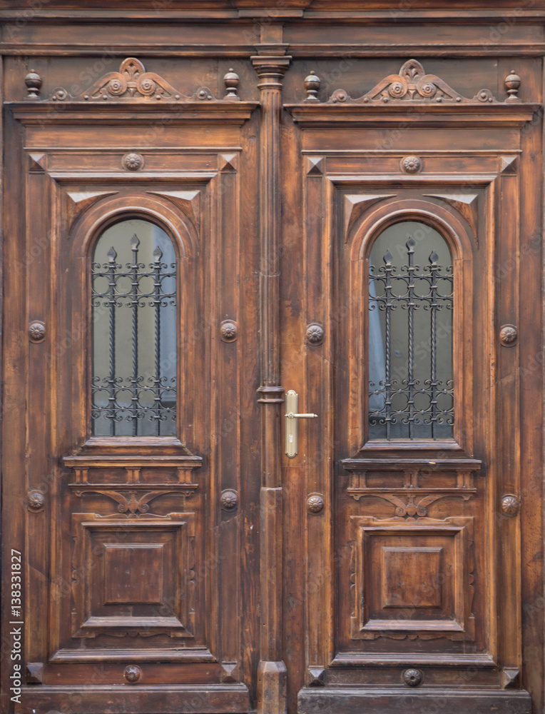 Old wooden brown door close-up with insertions and patterns on glass Old wooden brown door close-up with insertions and patterns on glass