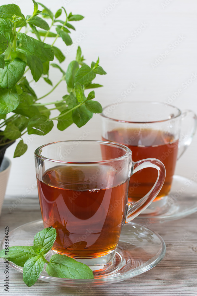 Black tea with mint. Grey wooden background. Black tea with mint. Grey wooden background.