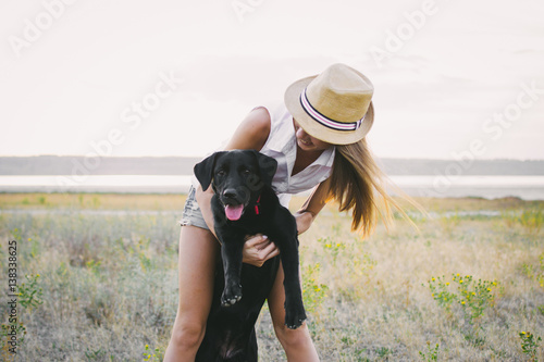 Young female hugging with labrador retriever dog  © sashafolly