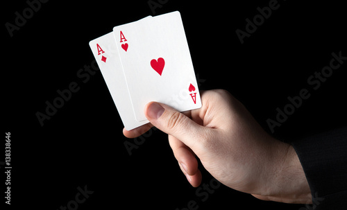 human hand holding two aces