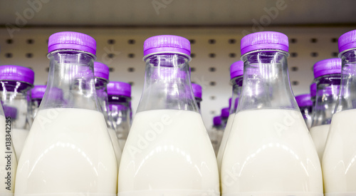 bottles with milk as dairy product for preparing breakfast wait for byers on market shelf