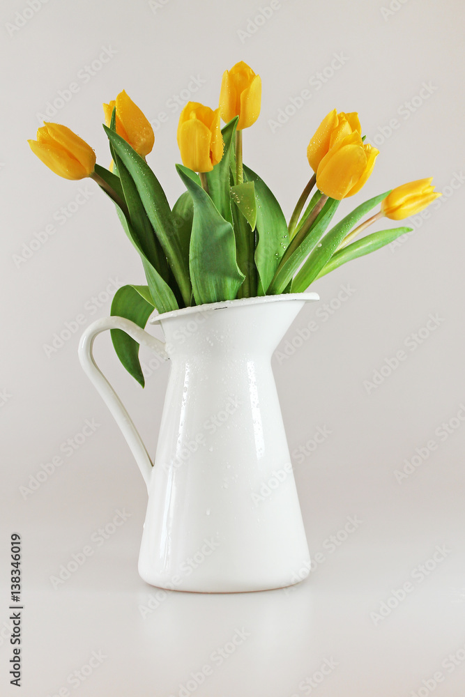Fototapeta premium Bouquet of fresh yellow tulips in jug